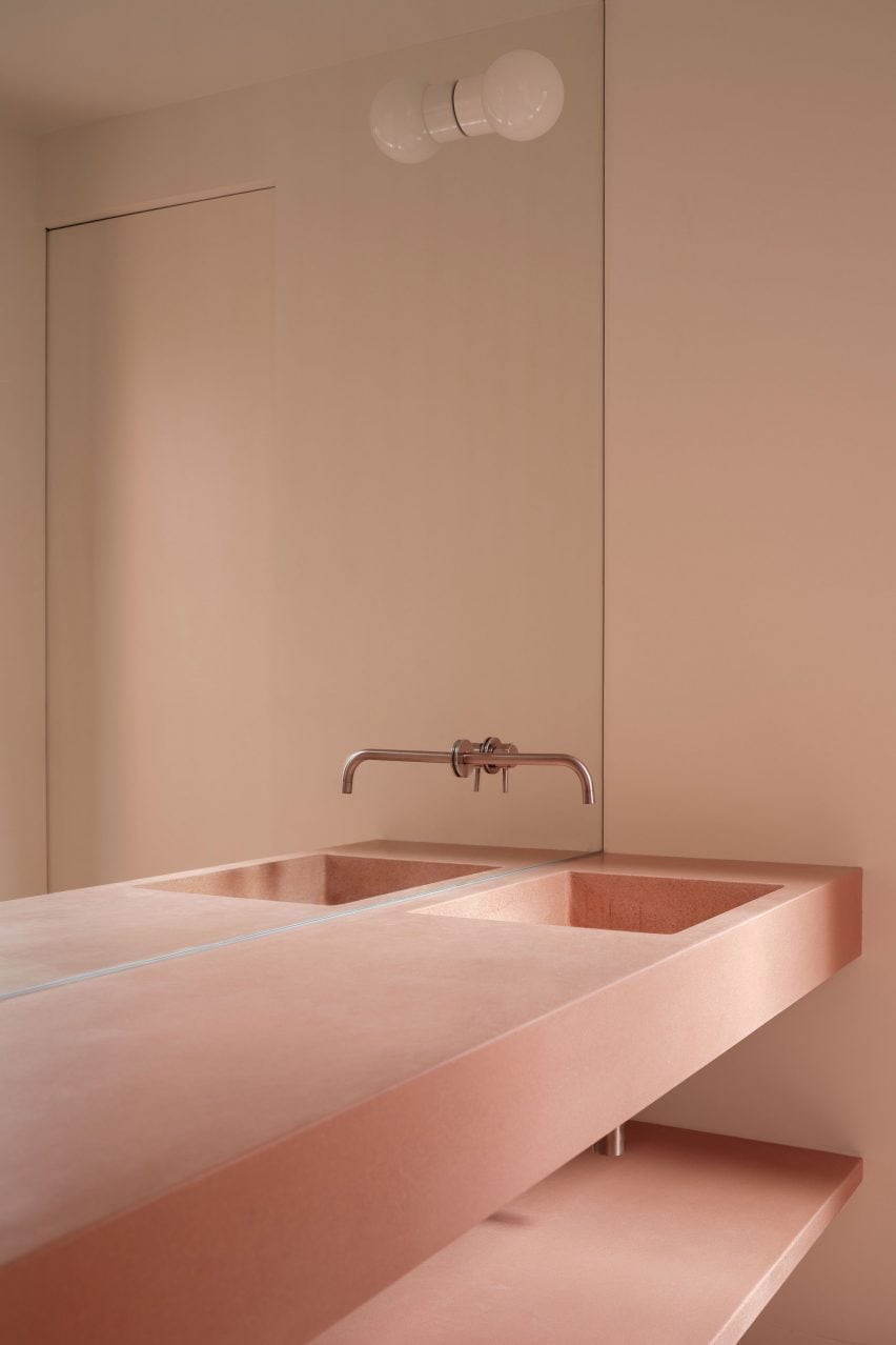 A bathroom with a pink concrete sink