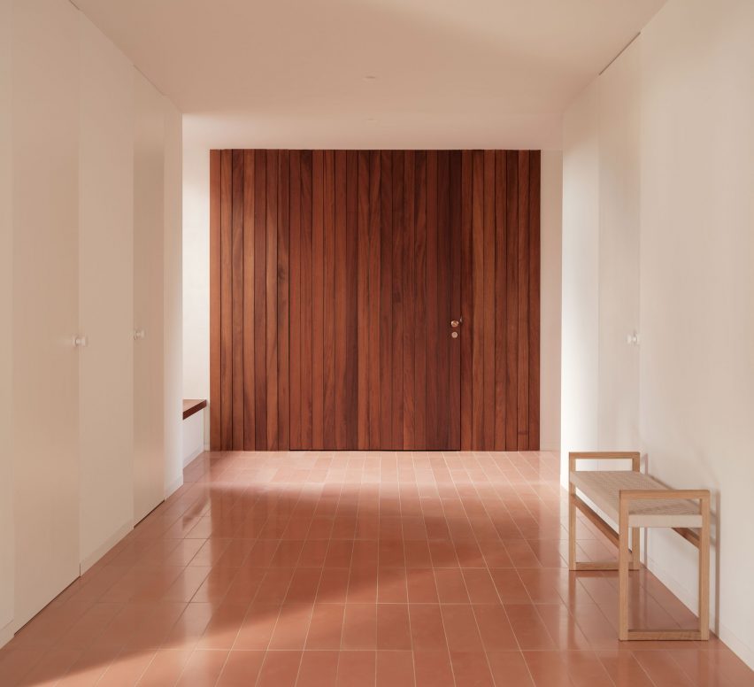 A holiday home entrance area with a pivoting wooden door