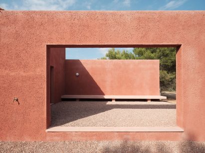 An opening in a facade covered in red-coloured mortar