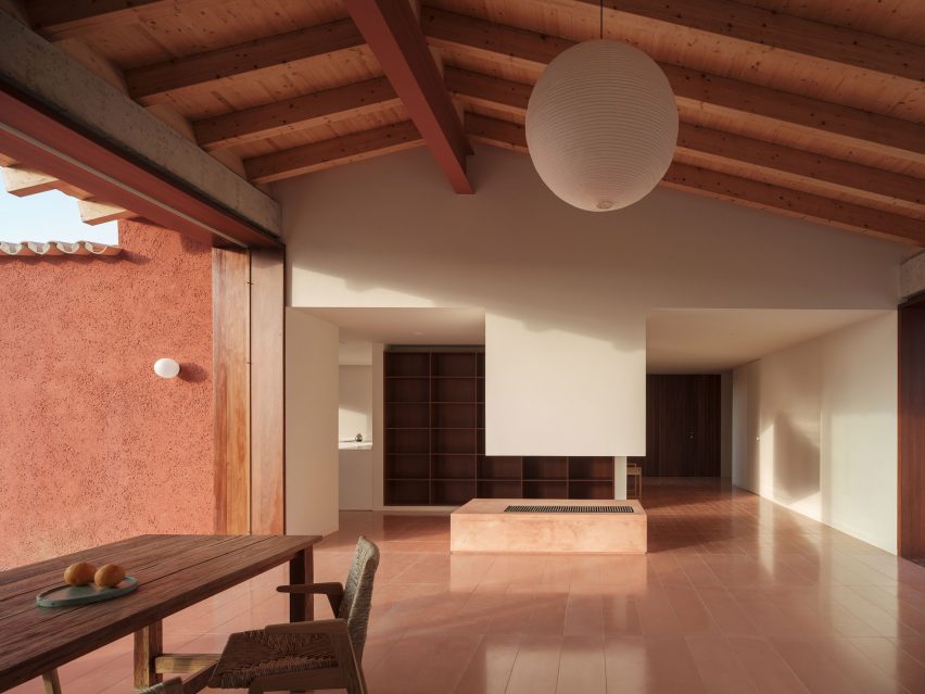 A living room with a tile floor and exposed wood ceiling