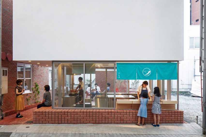 Customers outside brick-clad sweet store
