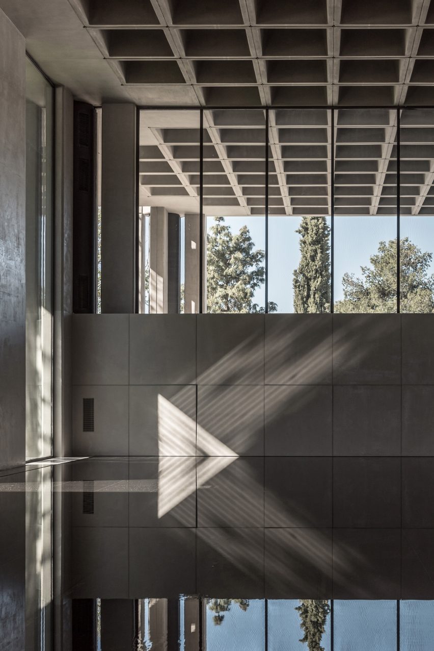 A pool of water inside a brutalist concrete building