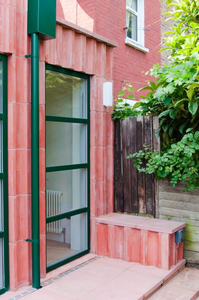 An extension clad in pink-coloured concrete blocks