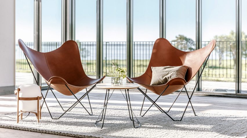 A pair of leather butterfly chairs with black steel frames