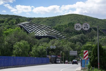 A curved shelter made from overlapping metal panels