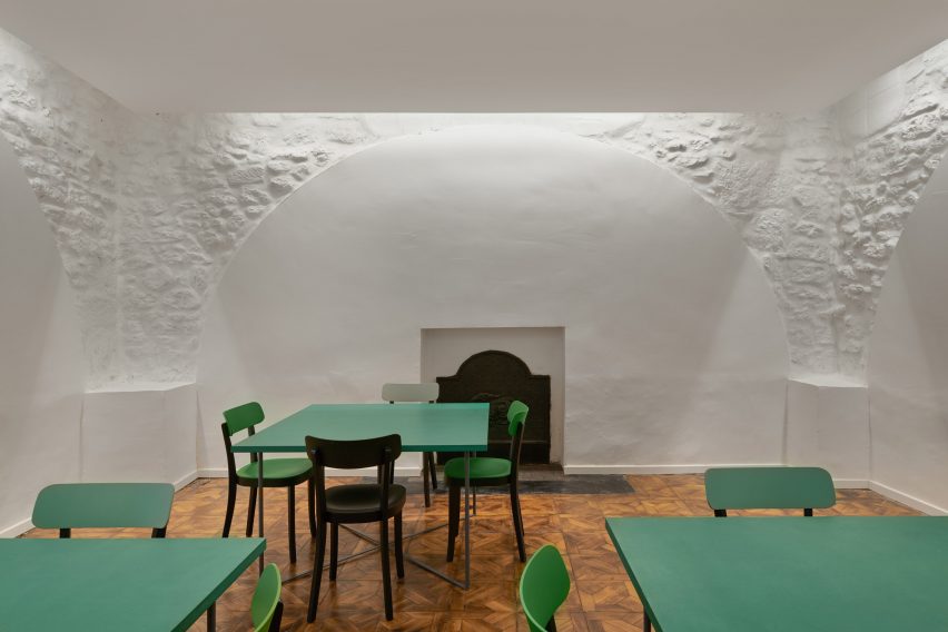Green tables fill the historic manor