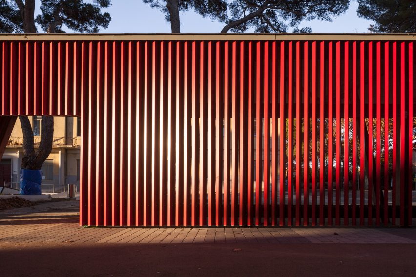A slatted red bus stop