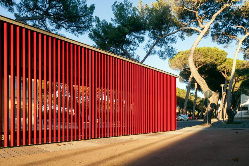 A slatted red bus stop