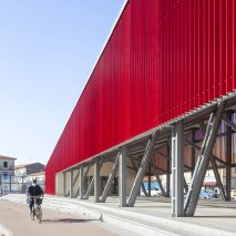 A cyclist beside a red pavilion