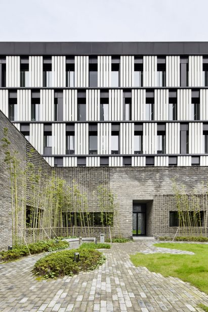 A monochrome office block with a grey brick base