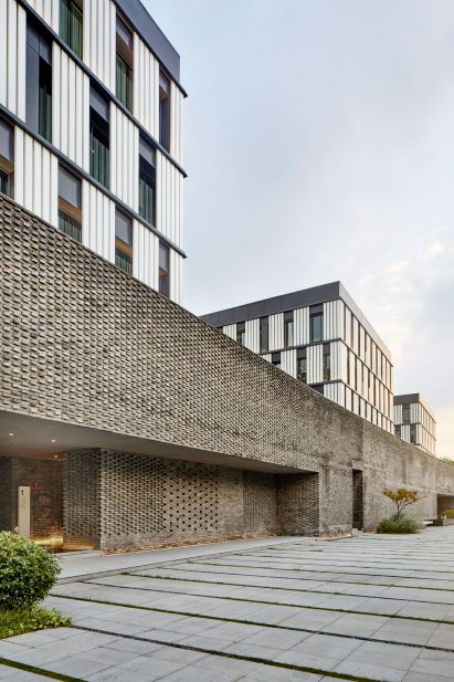 Three monochrome office blocks linked by a grey brick base