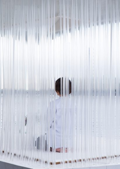 A person sitting on a floating pavilion with acrylic tube-sides