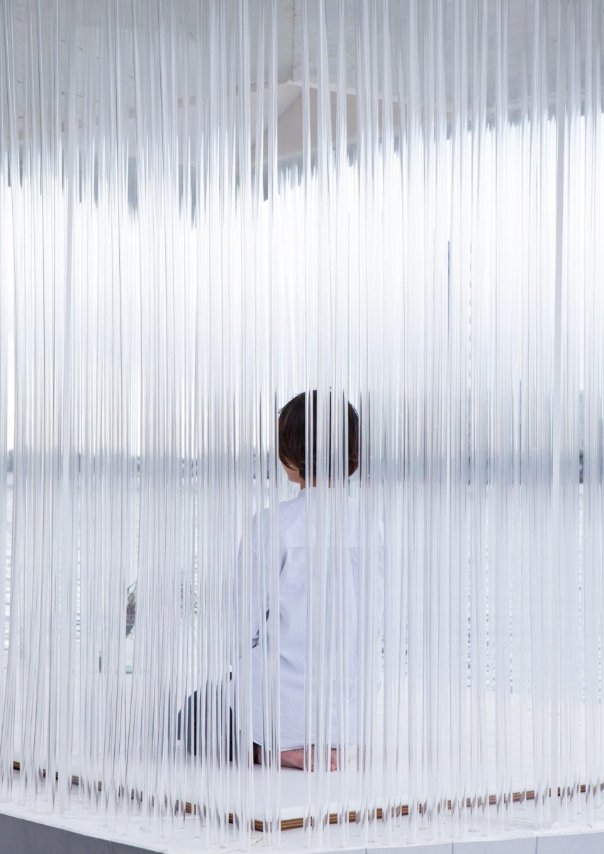 A person sitting on a floating pavilion with acrylic tube-sides