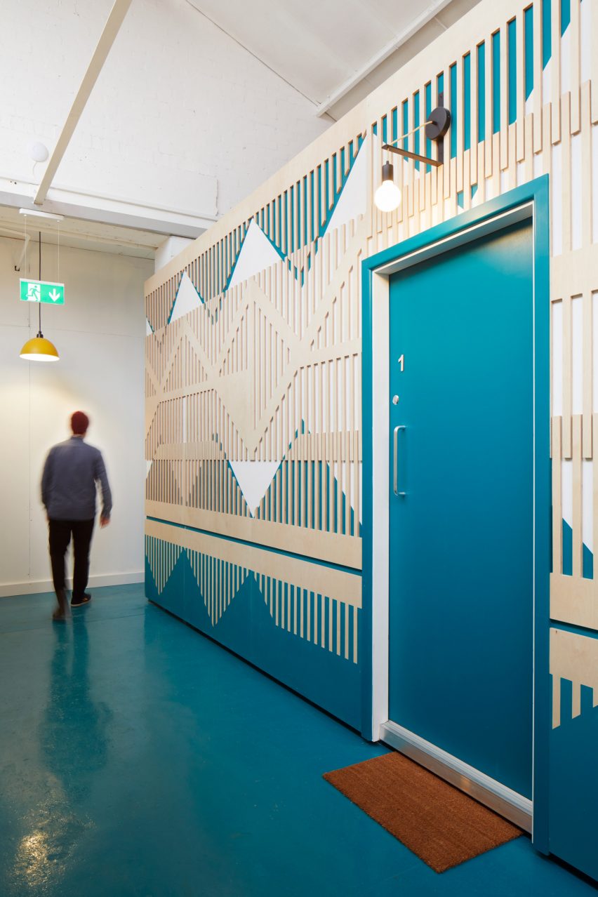 A patterned plywood wall inside The Axis