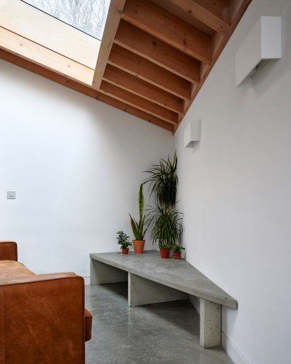 A white-walled living space with a timber ceiling