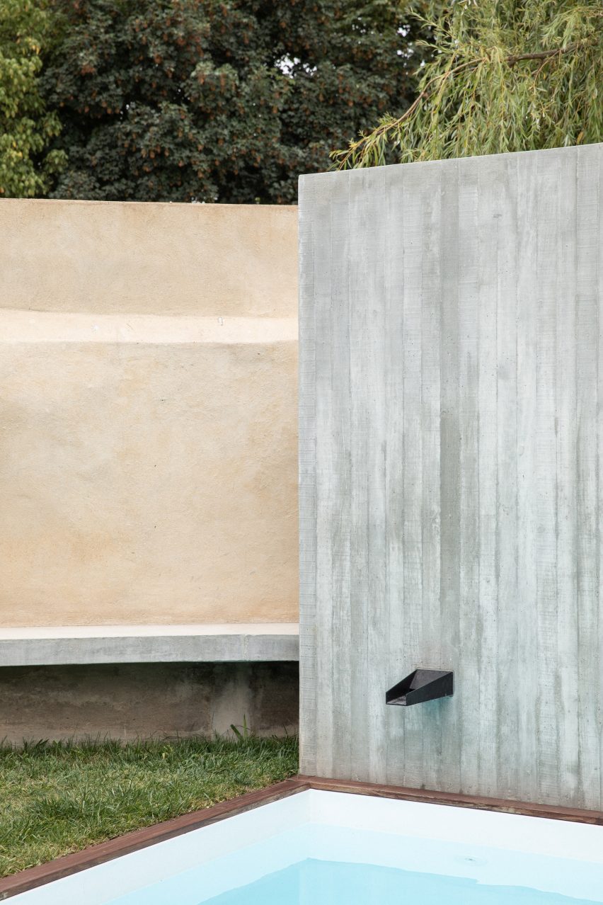 A water fountain is built within a concrete wall