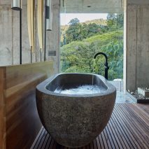 The bathroom has a a stone freestanding bath tub