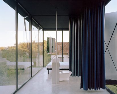 A glass-walled bedroom and bathroom