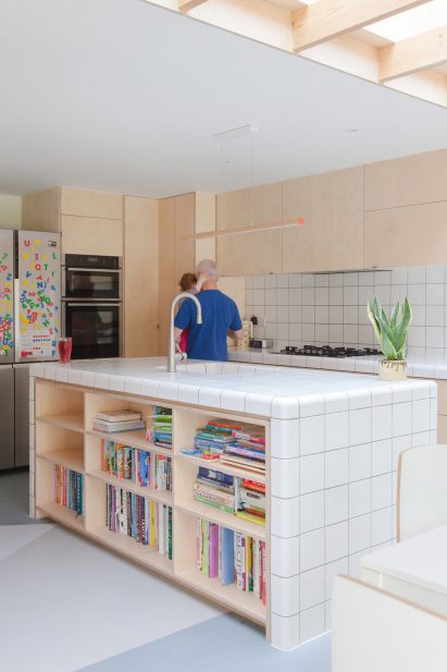 A wooden kitchen with a tiled island