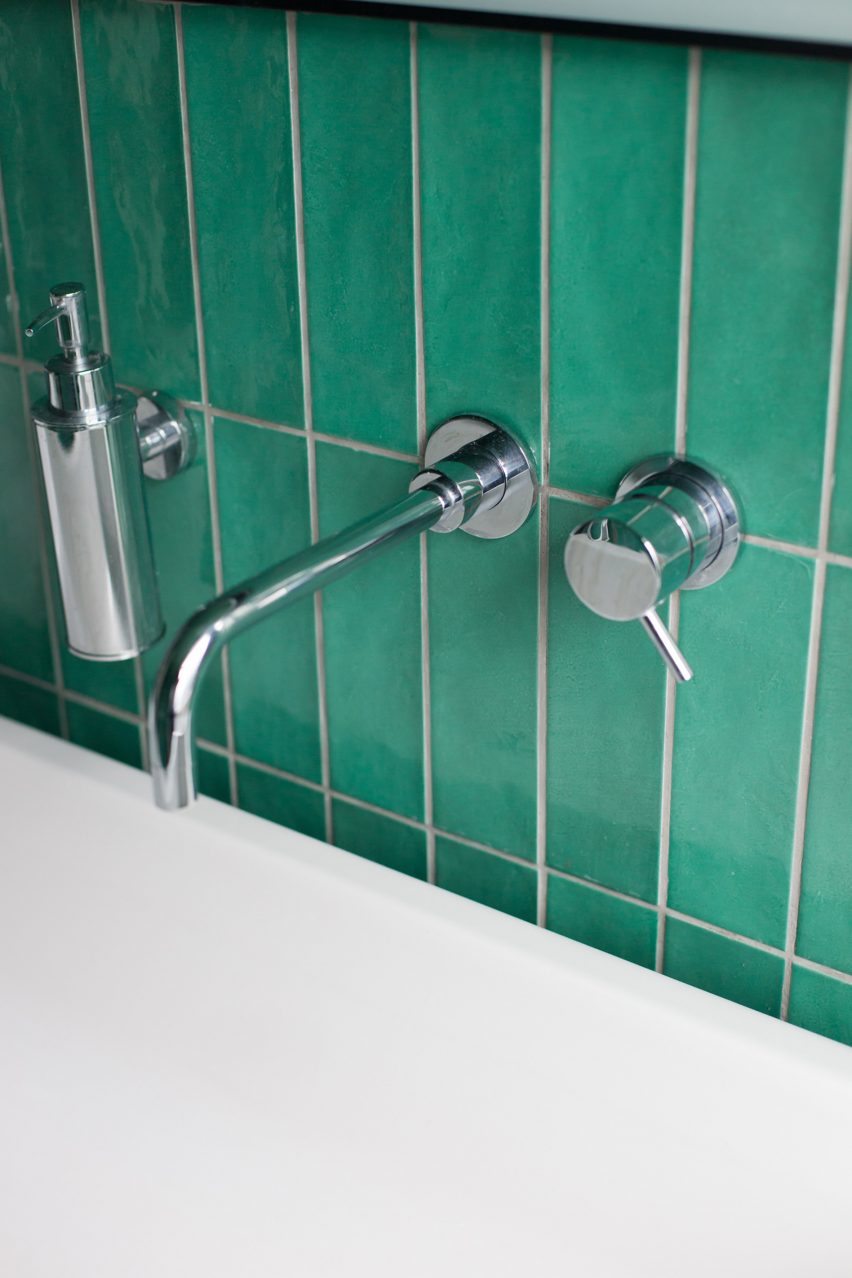A sink with green tiles