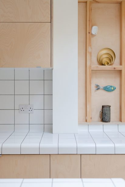 A wooden kitchen with tiled worktops