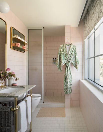 Bathroom in Goodtime Hotel with brass and green stone sink and light pink tiles