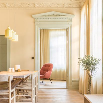 Pale yellow dining room with wooden floors