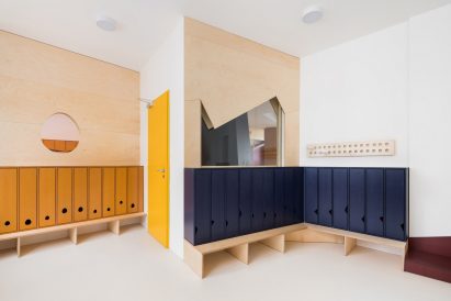 Dressing room with mustard yellow and navy blue lockers in Malvína Day Nursery