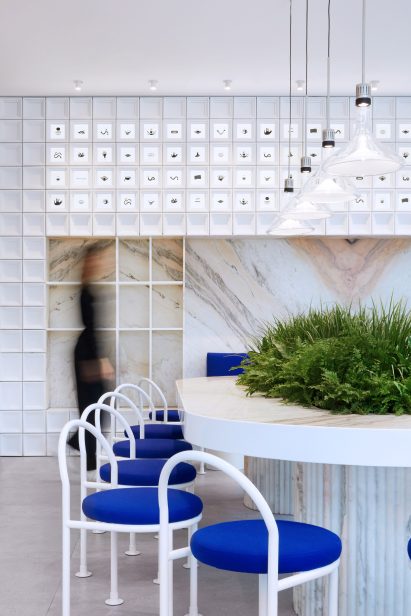 Communal table with marble top and white block wall in Mini Cuppa cafe