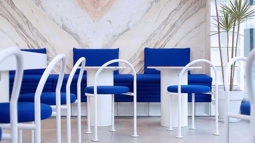 White steel furniture with indigo blue upholstery in seating area of Mini Cuppa tea shop by Raams Architecture Studio