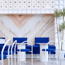 Marble panelling and white MDF blocks in seating area of Mini Cuppa tea shop by Raams Architecture Studio
