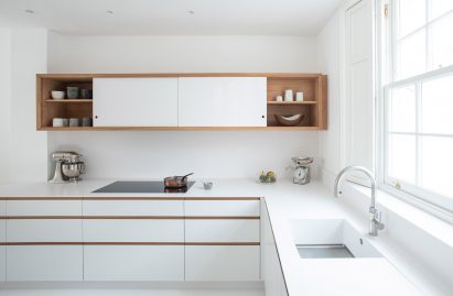 The kitchen has a white and oak palette