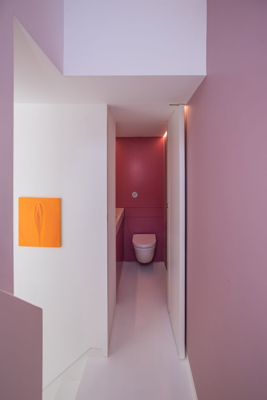 Pink hued walls line the stairwell