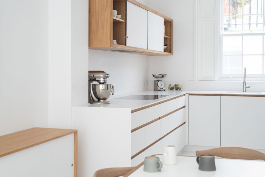 The kitchen combines white and oak