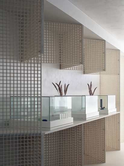 Zigzagging walls and glass display vitrines in cannabis dispensary interior by StudioAC 