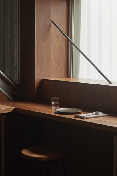 Wooden counter seating and stool in restaurant interior by Pattern