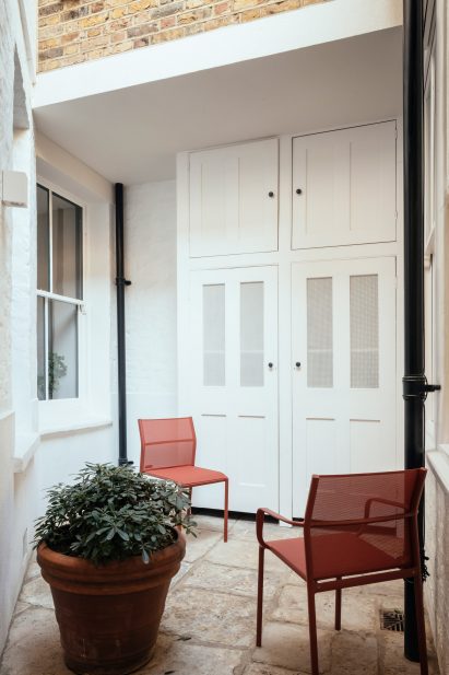 Georgian stone courtyard of Unearthed Vault apartment with red chairs