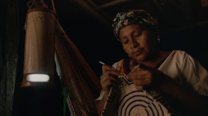 Wayúu artisan working at night using a lamp powered by salt water