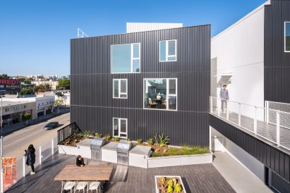 Westgate1515 has facades made of white stucco and black, corrugated metal