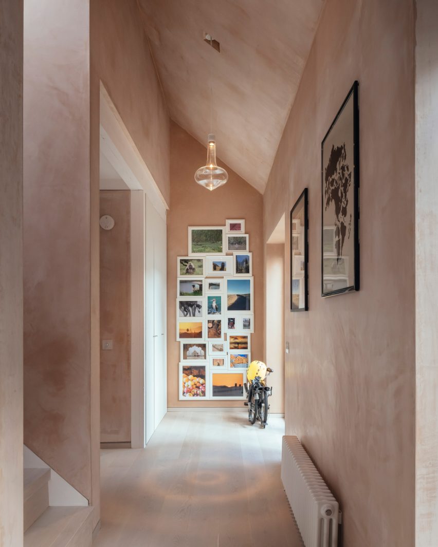 Corridor with pink plaster walls and frame art