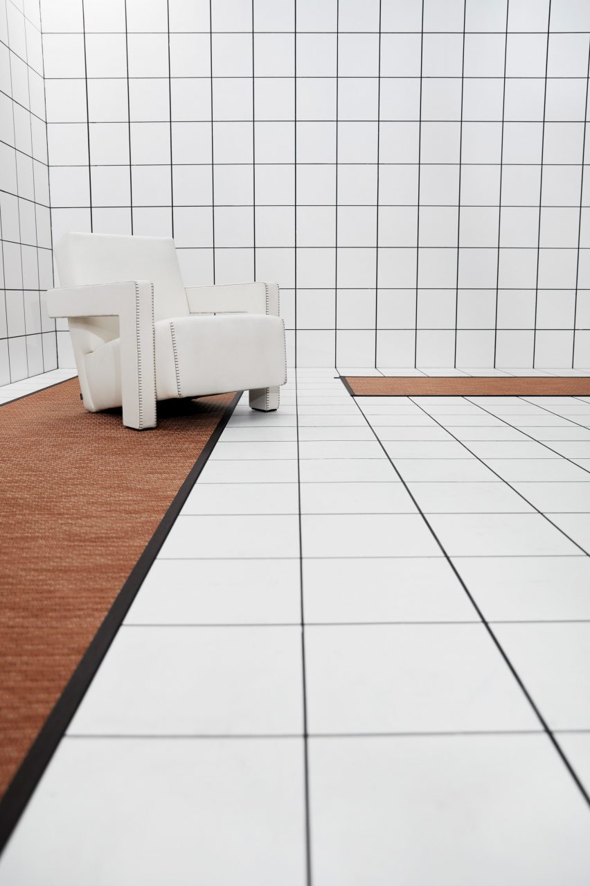 A white room with long terracotta-coloured rugs