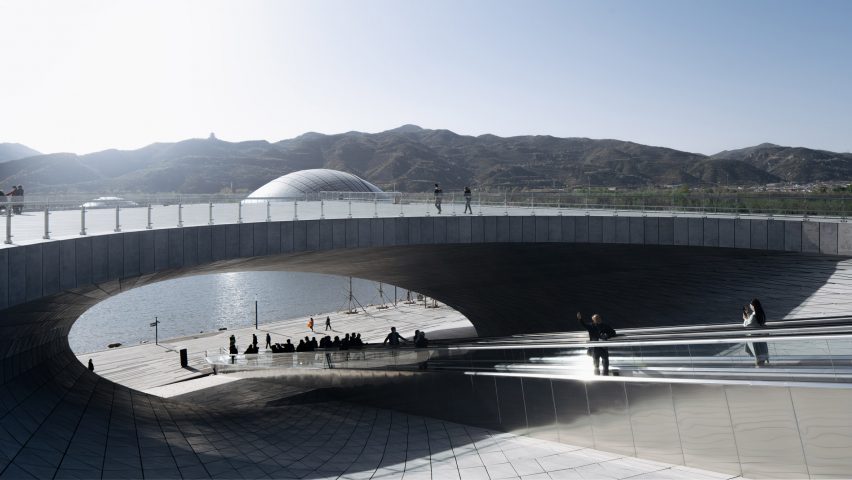 A walkway passes under and opening in a building