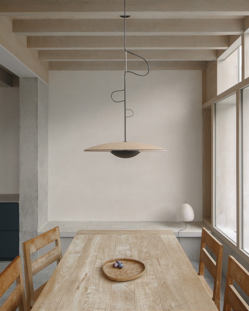A pendant light is suspended over a dining table