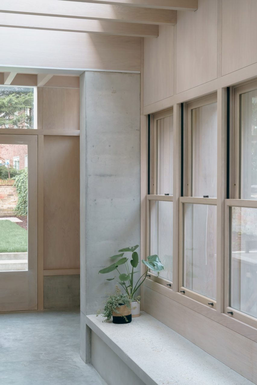 A concrete bench is located beneath the windows
