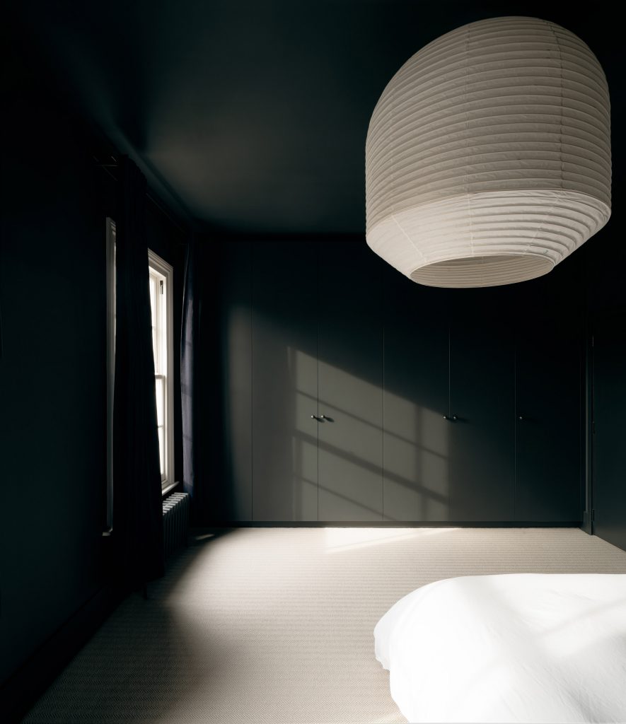 A large pendant light hangs in the bedroom