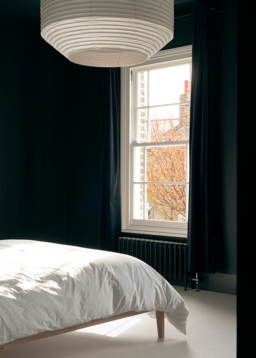 A bedroom was finished with dark walls and light carpet floors