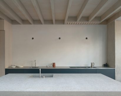 The kitchen island in Concrete Plinth House has a stone counter top