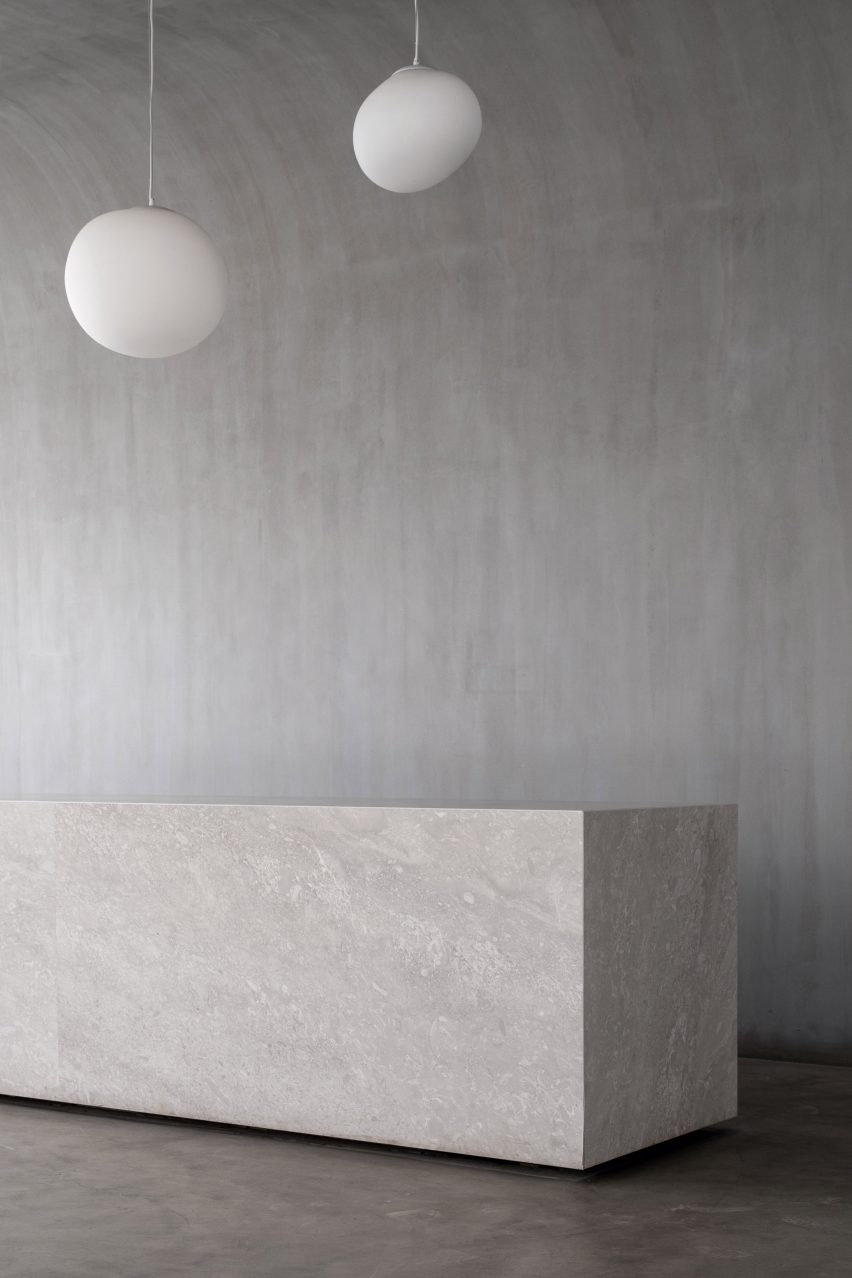 A concrete reception desk is located in the hotel
