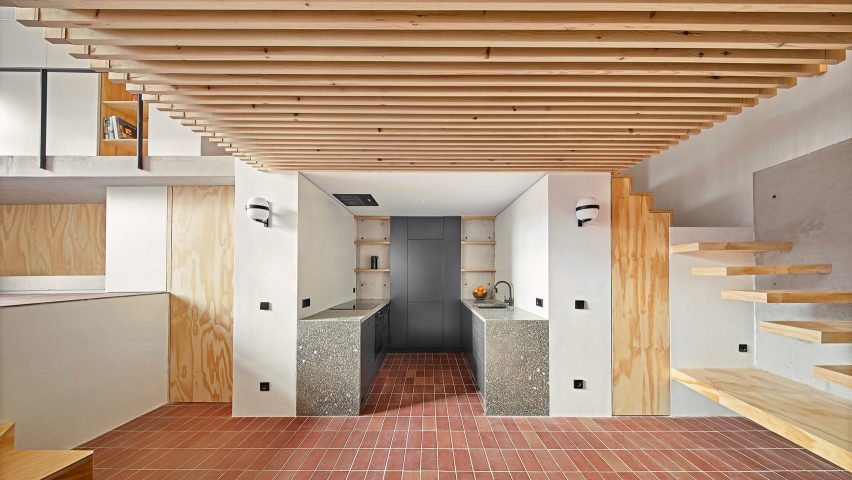 Wood lines the ceiling of the kitchen area