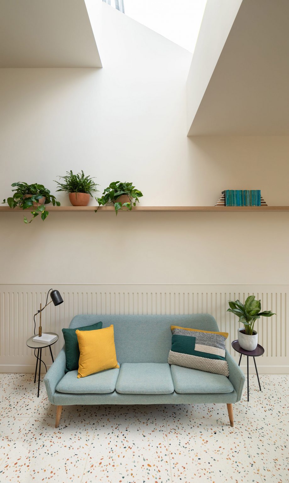 A living room with a blue sofa and terrazzo floor